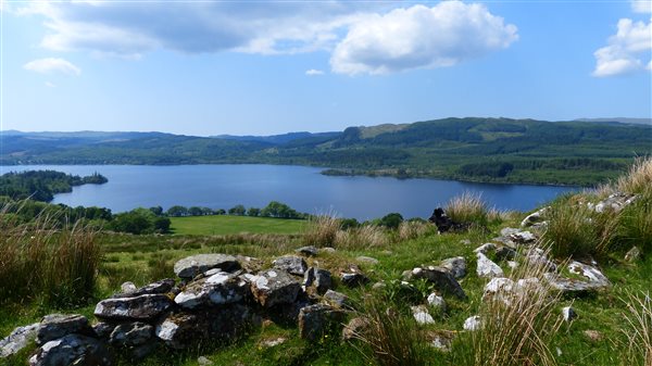 stone wall with scottish loch in distance